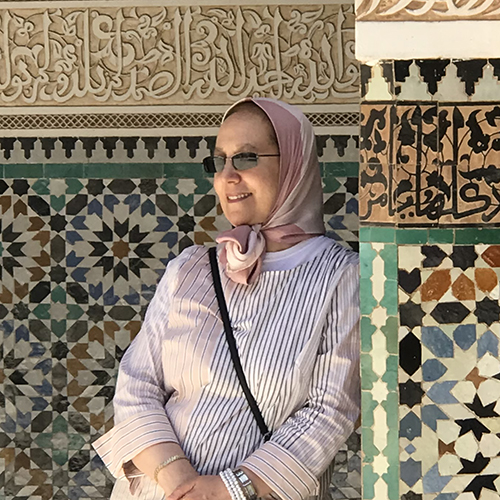 Amina Moujtahid in Morocco, with mosaic walls in the background.