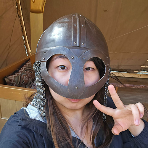 Skylar Rhim wearing a traditional metal armor helmet on her head.
