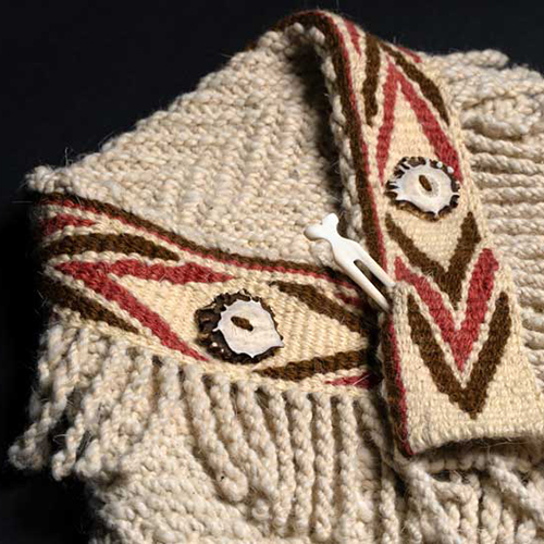 Handwoven shawl or jacket with a Native American design at collar edge.