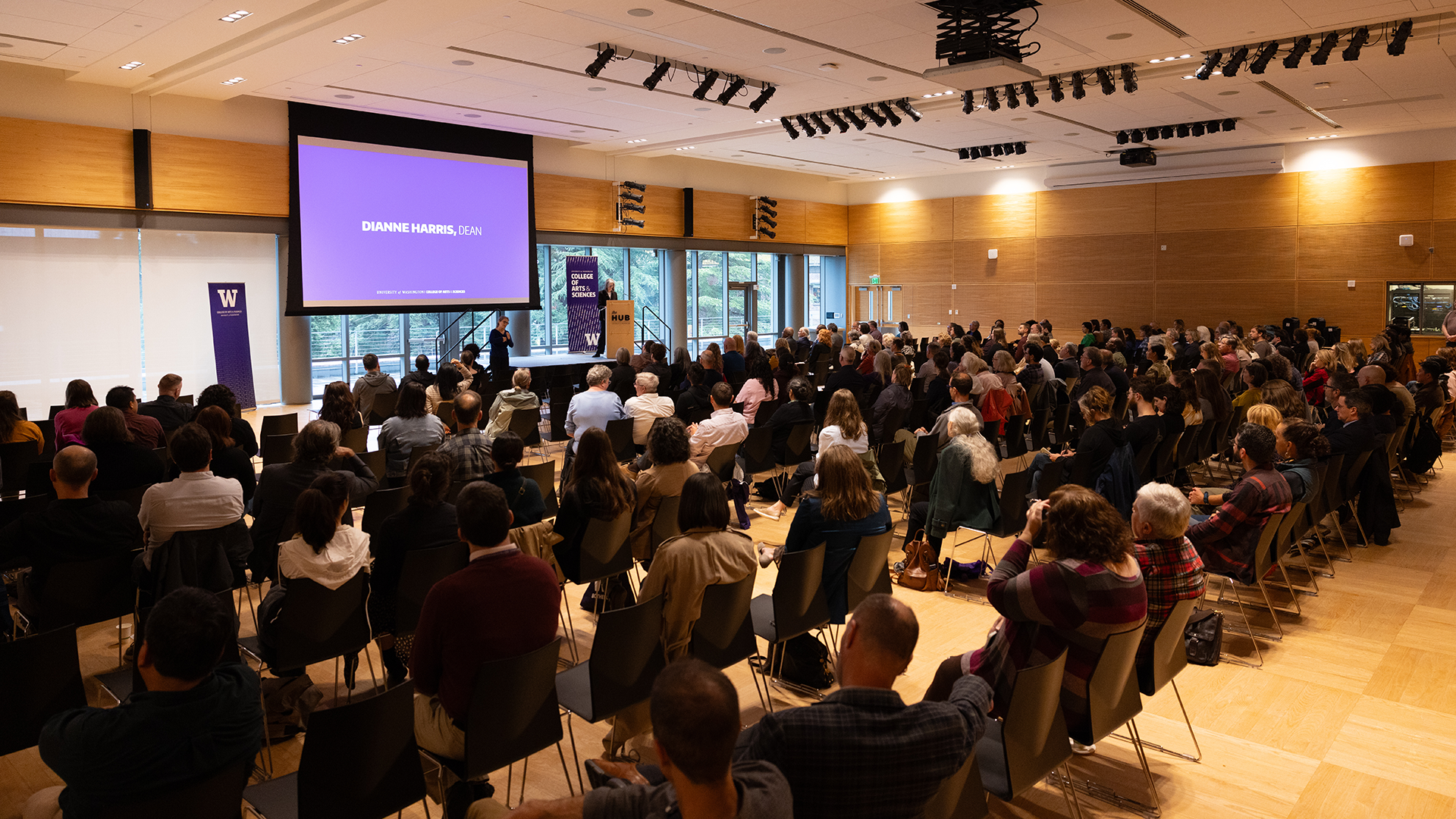 A room full of people watching a speech
