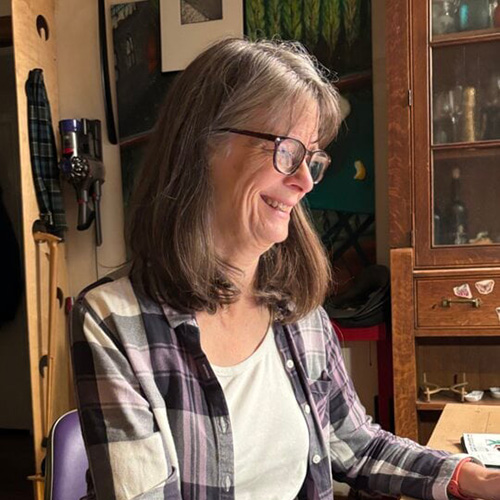 Mary Brunkow sitting at table in her home