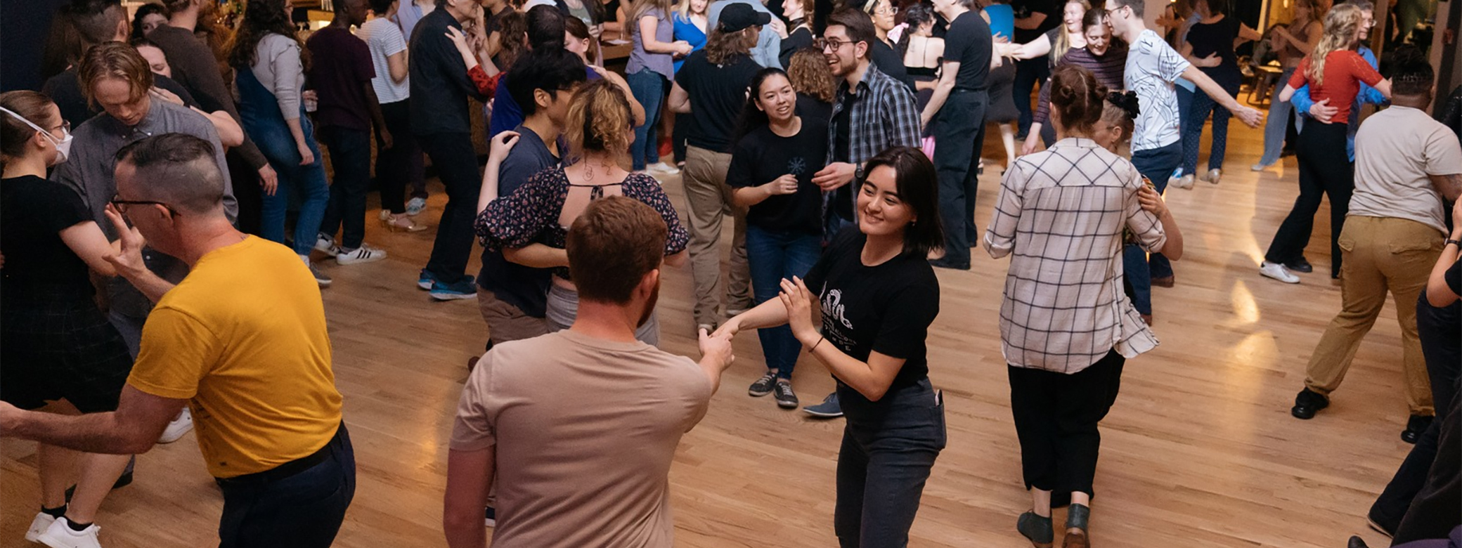 A ballroom filled with couples dancing in casual clothes