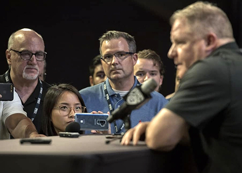 Thuc Nhi Nguyen with other reporters interviewing UCLA football coach Chip Kelly in 2018. 