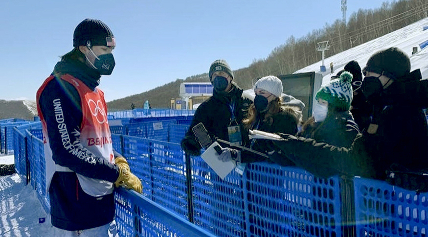 Thuc Nhi Nguyen and three other reporters, all bundled up for the frigid weather, interview Olympic freeskier Alex Hall at the 2022 Beijing Olympics.