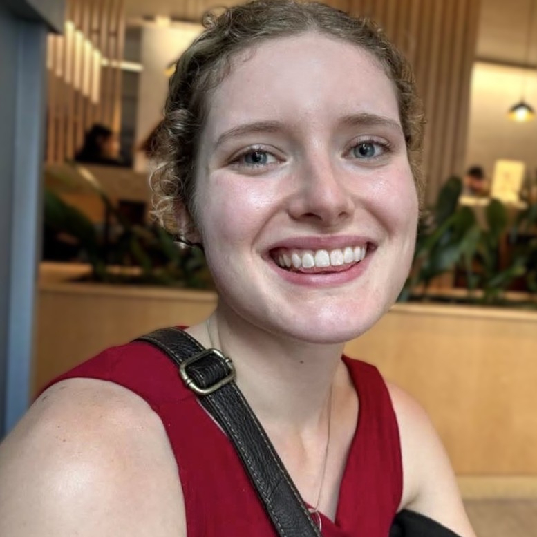 A smiling young woman in a bright red top.