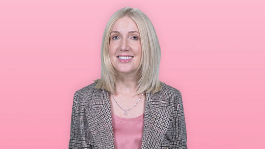 Nicole McNichols with a pink background behind her.