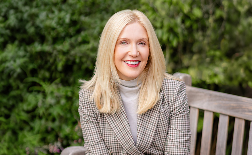 Professor Nicole McNichols sitting on a bench on the UW campus.