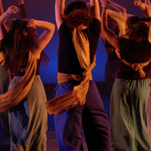 A group of students dancing in a circle; Photo by Michael B Maine