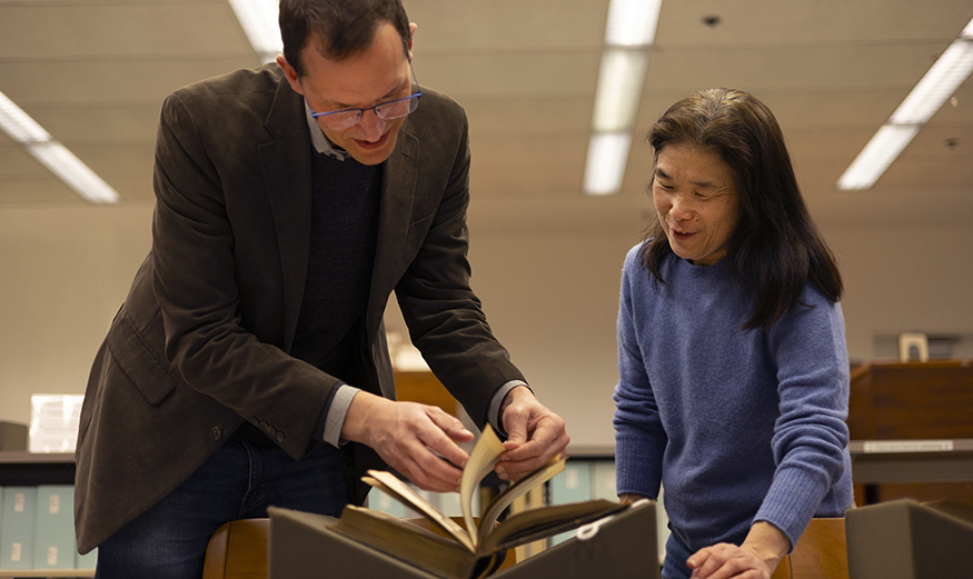 Scott Magelssen and Julie Tanaka look at an illustrated Shakespeare book donated to UW Libraries. 