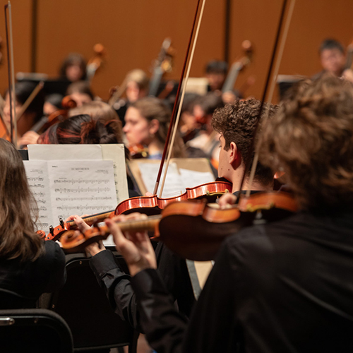 UW Symphony performing, with photo taken just behind violin players