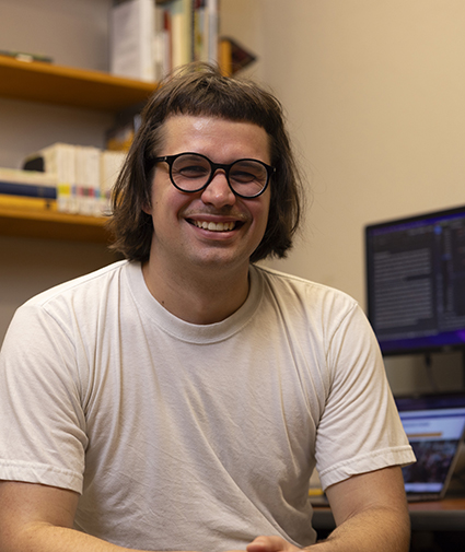 Greg Rahuoja sitting by his computer in a UW office.