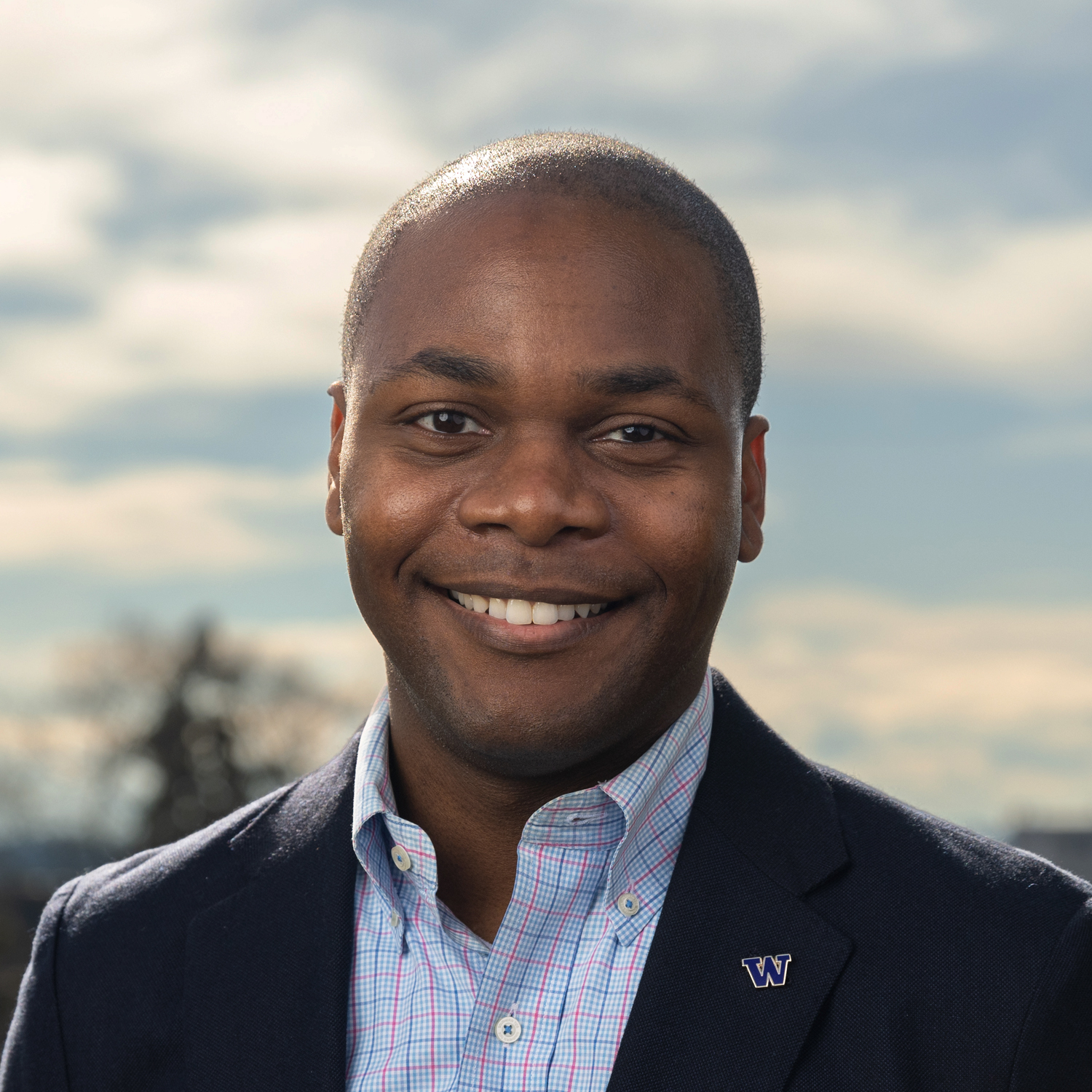 Kevin Thompson smiles before a cloudy sky.