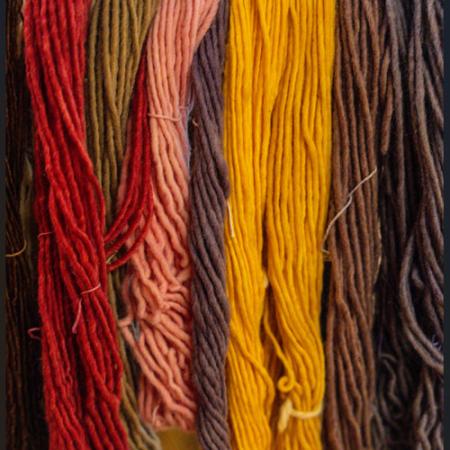 A close-up photo of yarns colored with natural dyes. 