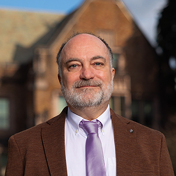 Headshot of Richard Wright standing in front of campus building