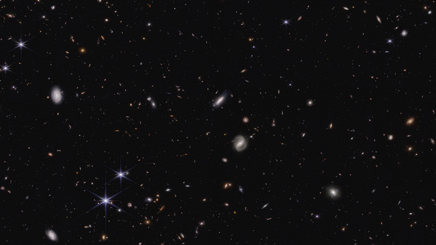 Distant galaxies appear as white dots of varying sizes in a sea of black.