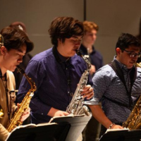 Students play saxophone on stage