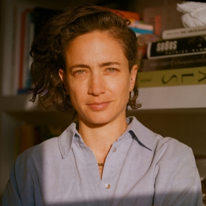 Paola Ramos poses in a sun-drenched office.
