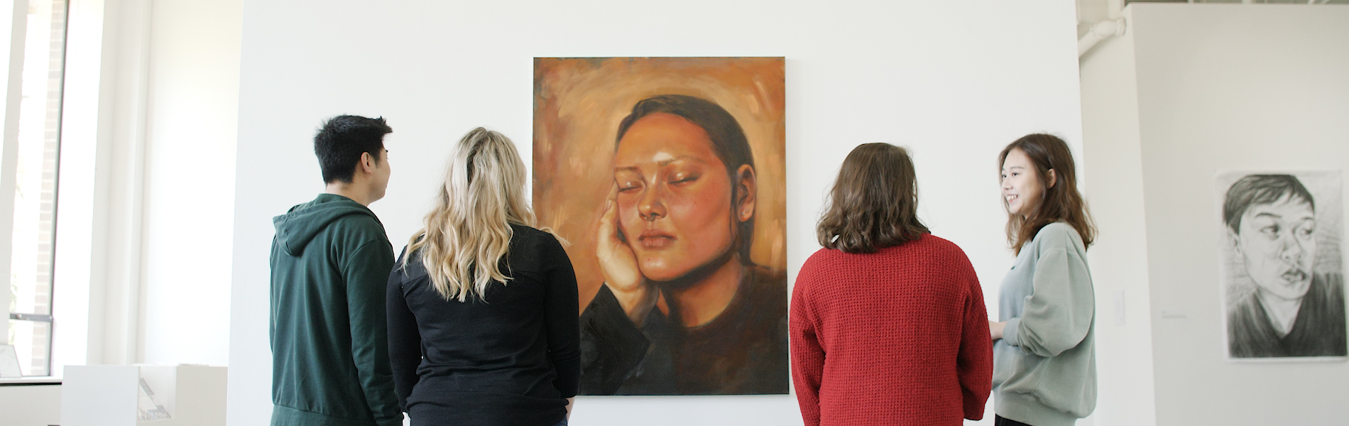 Group standing in front of and discussing a painting in a gallery