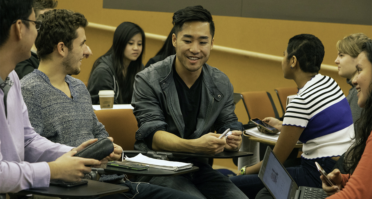 Students talking in groups in the classroom. 