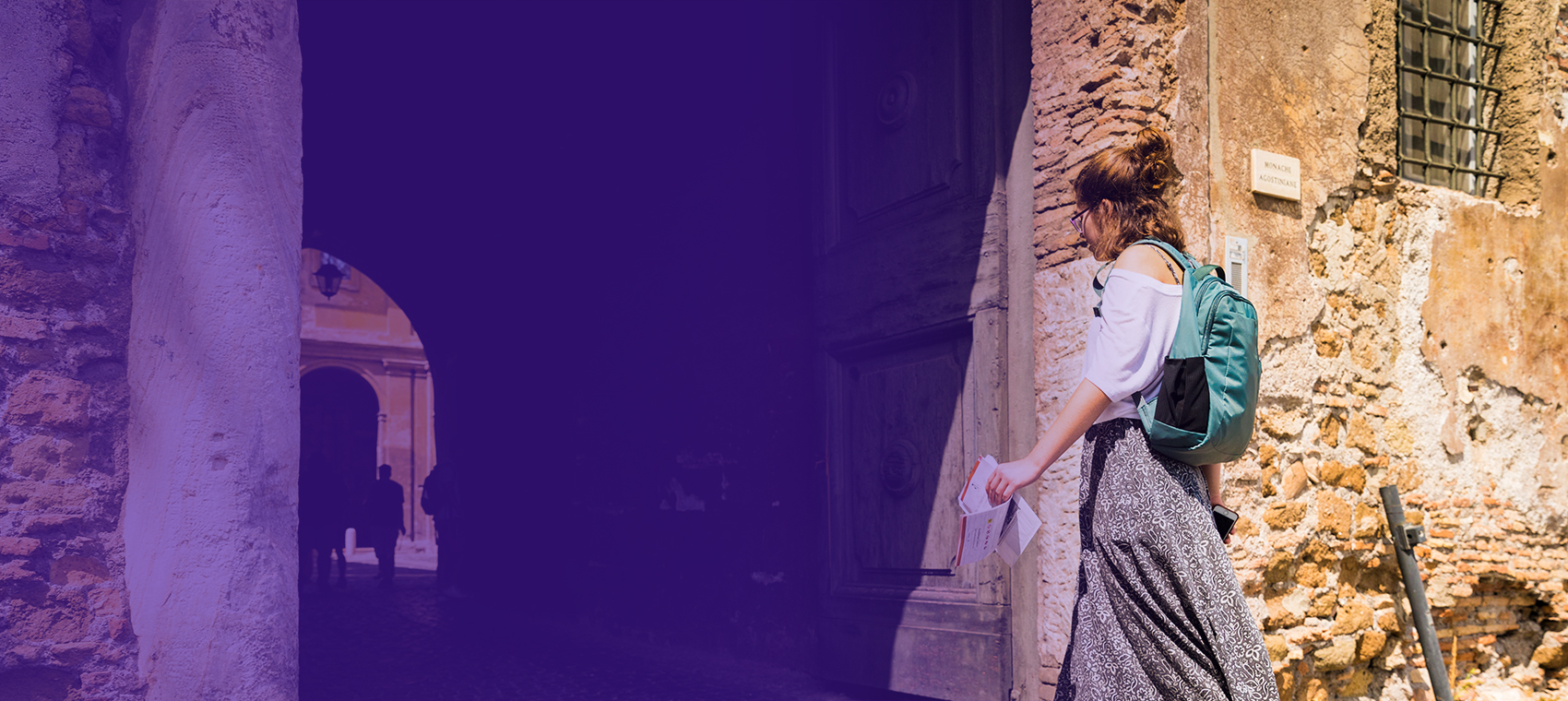 Student walking through Roman alleyway